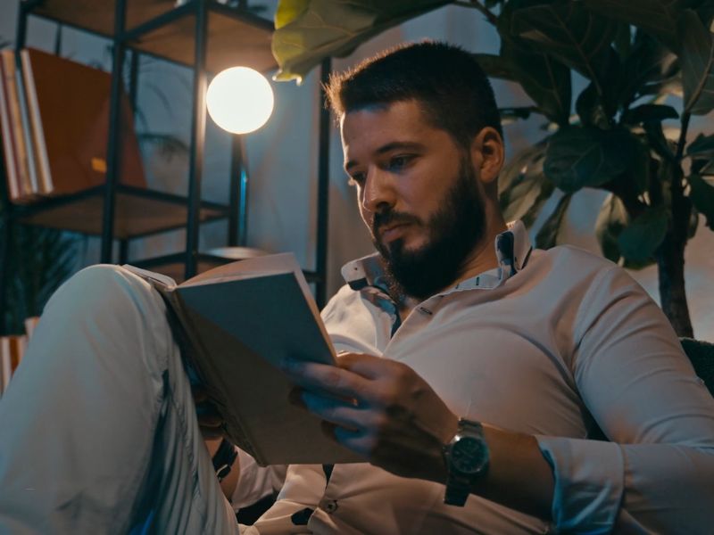 momak sedi i čita knjigu