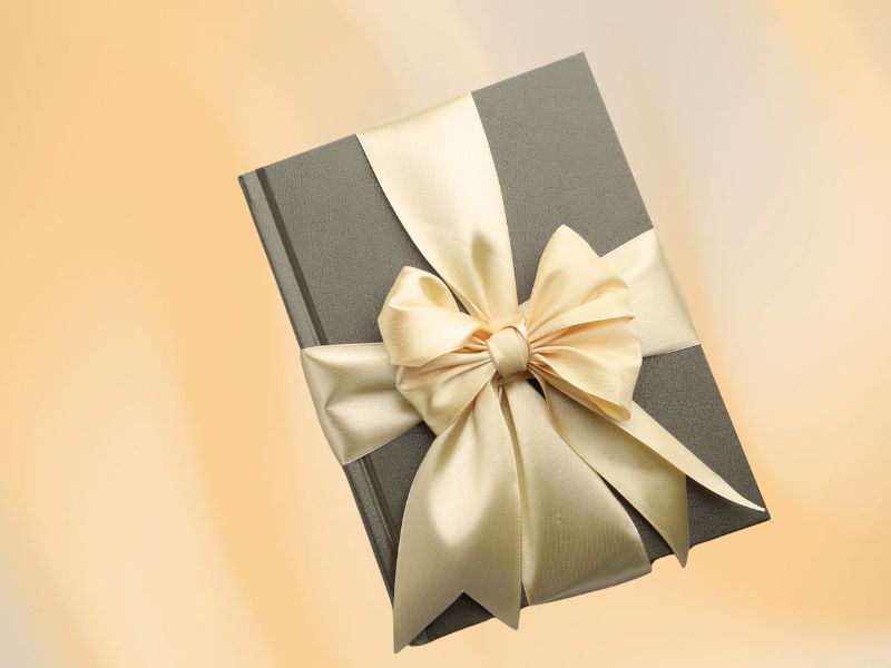 knjiga upakovana u mašnu na krem pozadini